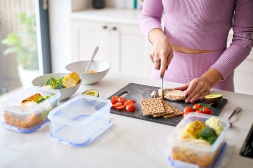Preview: Close Up Of Woman Wearing Fitness Clothing At Home In Kitchen Making Healthy Meals For The Freezer