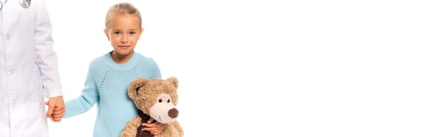 Preview: Panoramic crop of girl holding teddy bear and hand of doctor isolated on white