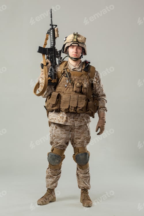 Preview: Soldier posing with weapon in military gear in a studio setting during daylight hours