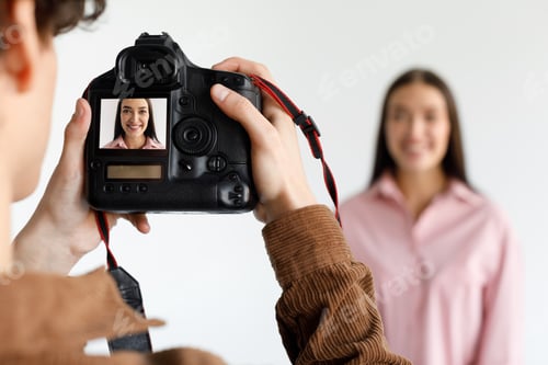 Preview: Photographer taking portrait of young beautiful woman in photostudio, focus on working digital