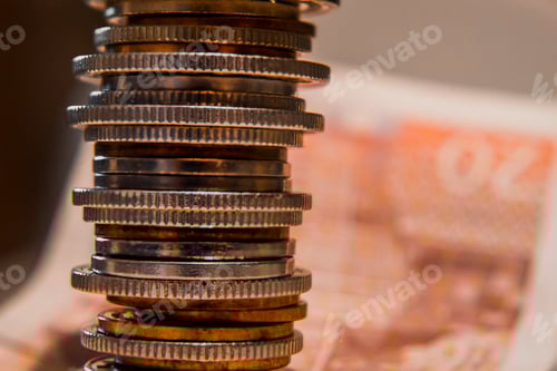 Preview: Closeup shot of various coins stacked on top of each other on a banknote background