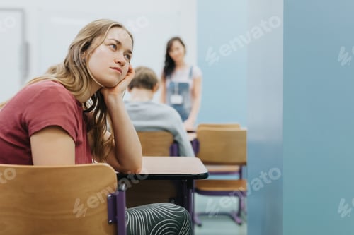 Preview: Beautiful thoughtful teenage girl sits on the side of a class during lesson at school
