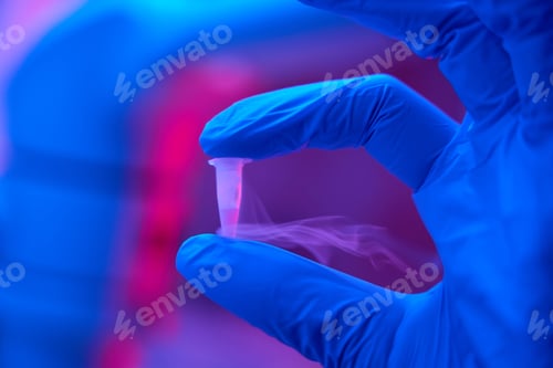 Preview: Laboratory assistant in protective gloves holds a small test tube