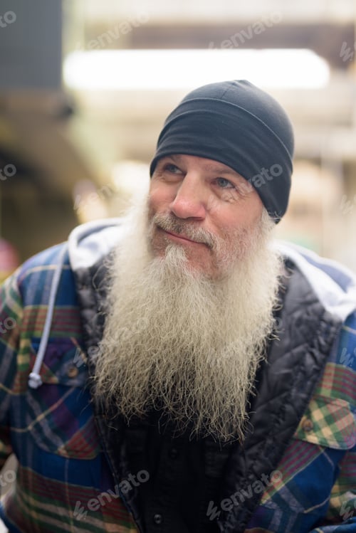 Preview: Face of mature bearded hipster man thinking in the city streets