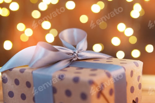 Preview: Close-up of Wrapped Gift with Ribbon and Lights