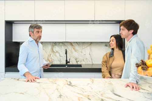 Preview: Couple choosing kitchen design with interior designer in showroom
