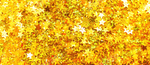 Preview: Glittering background of golden sequins in form of stars closeup. Sparkle festive texture.