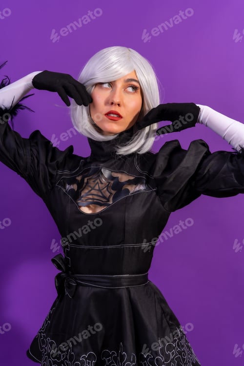 Preview: Portrait of cosplay woman in a black costume and a white wig in studio on a purple background