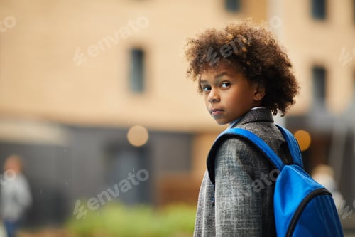 Preview: Child with Backpack Looks Back Over Shoulder