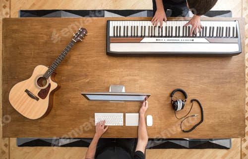 Preview: Top view of sound engineers at wooden table working in studio.