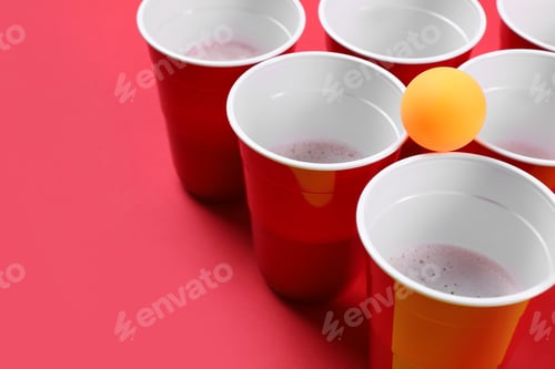 Preview: Plastic cups and ball on red background, space for text. Beer pong game