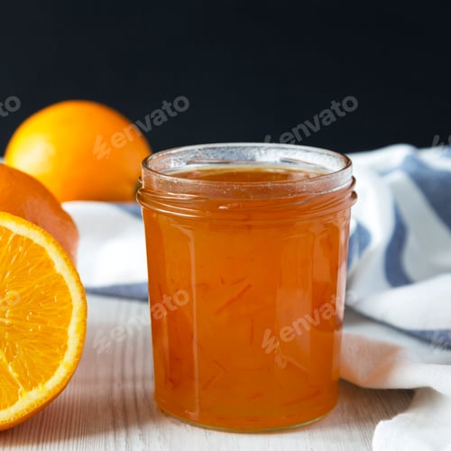 Preview: Homemade orange marmelade in glass jar, side view. Close-up.