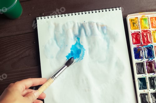 Preview: Person Painting with Watercolor at Home on Table