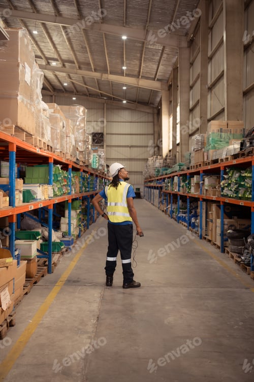 Preview: Portrait of male worker wearing hardhat and reflective vest holding hand scanner working