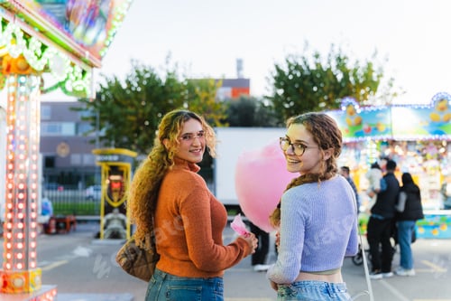 Preview: Friends enjoying carnival fun holding cotton candy
