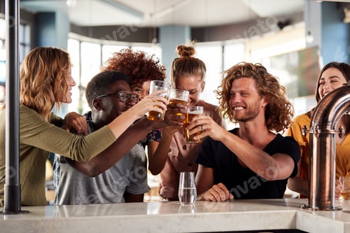 Preview: Group Of Male And Female Friends Celebrating Whilst Watching Game On Screen In Sports Bar