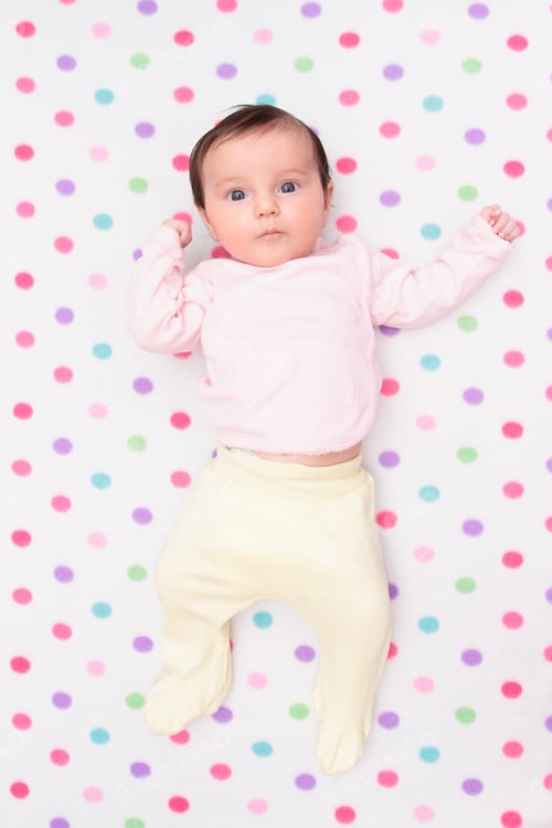 Preview: Little baby girl laying on blanket. Portrait of newborn baby happy cute kid on polka-dot blanket