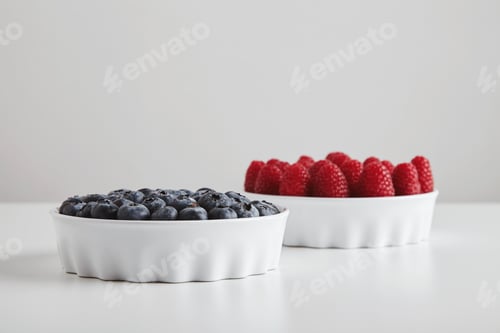 Preview: Heap of ripe raspberries blueberries in ceramic bowls