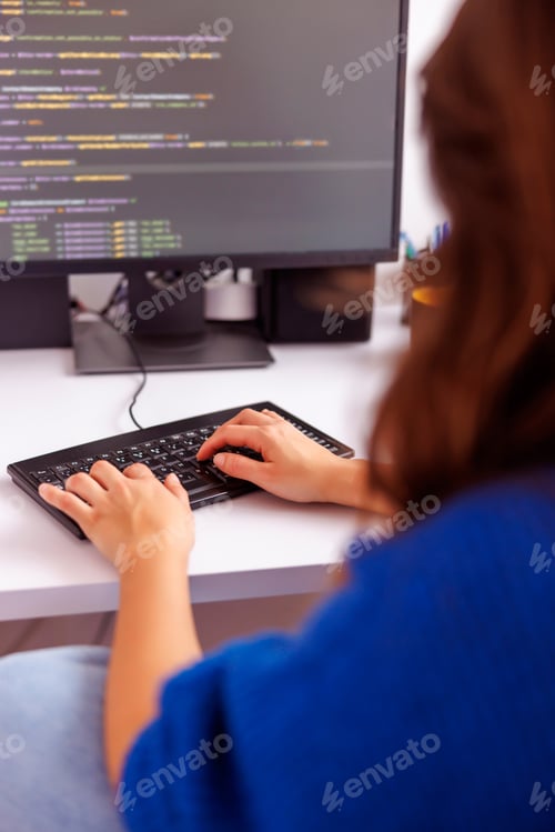 Preview: Female software developer coding while working in home office