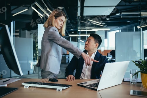 Preview: happy coworkers discuss project strategy by looking and pointing at laptop pc computer