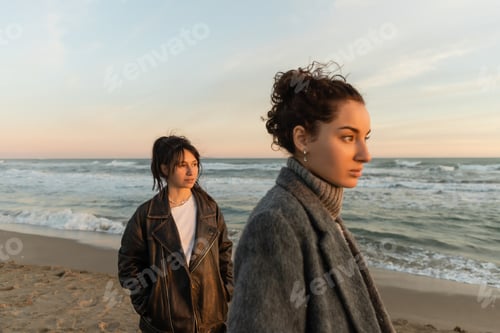 Preview: Young women looking away while standing on beach in Spain