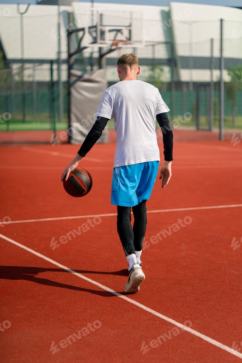 Preview: Tall guy basketball player with the ball shows his dribbling skills during practice