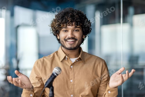 Preview: Handsome arab businessman sitting in stylish office and speaking in front of microphone. Positive