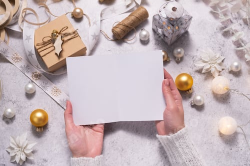 Preview: Female hands are holding a Christmas card. Festive atmosphere during Christmas time.