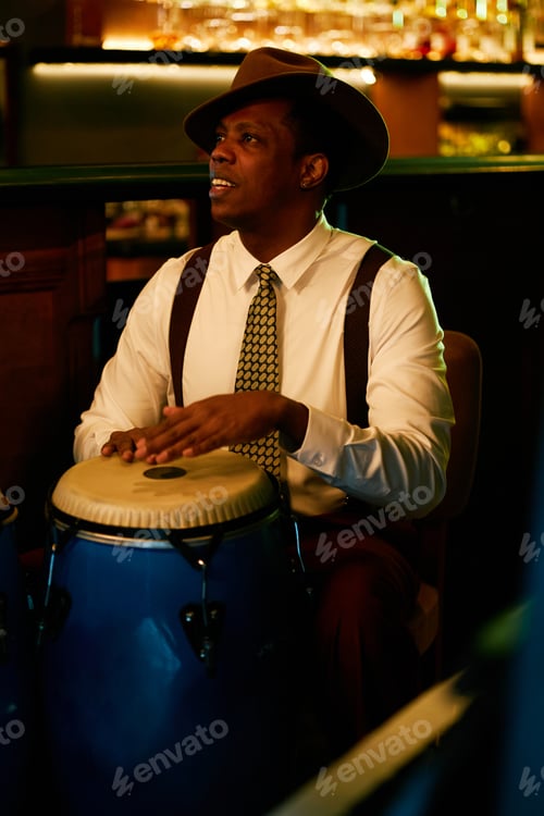 Preview: Black Man in Hat Improvising on Congas while Playing Music in Jazz Club
