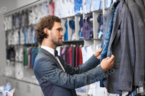 Preview: Man with curly hair picking up suits