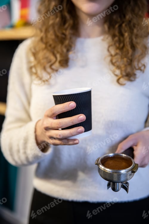 Preview: A female hand holds a holder and a glass, the process of making coffee.