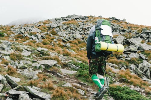 Preview: Lonely tourist with a backpack on a mountainside