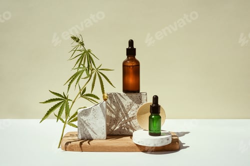 Preview: CBD oil, cannabis setting in different bottles and marijuana leaf in astill life on geometric podium