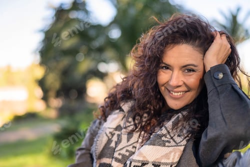 Preview: Happy woman smiling outdoors demonstrating wellness concept