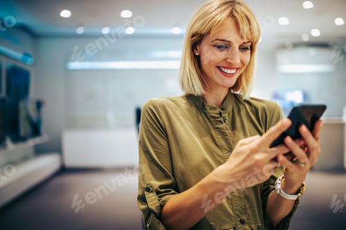 Preview: Woman entrepreneur taking a break from work checking her cell phone.
