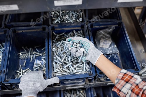 Preview: Above angle of gloved hands of female machinery builder holding pile of bolts