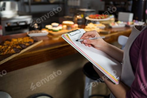 Preview: Mid-section of staff maintaining records on clipboard