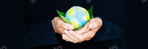Preview: Young woman holding small planet in hands against black dark background