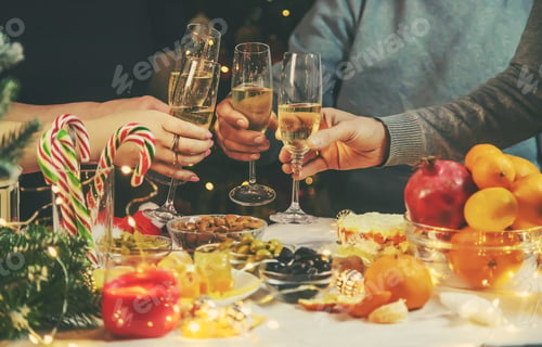 Preview: Champagne in hand against the background of the Christmas tree. People. Selective focus.