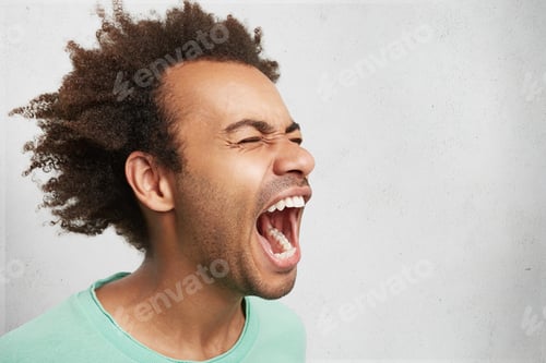 Preview: Horizontal portrait of man with dark skin and Afro hairstyle screams in despair, opens mouth widely,