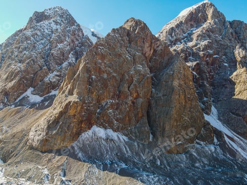 Preview: Close-up aerial view of rugged, rocky mountain peaks with snow