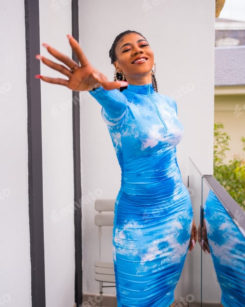 Preview: Fashion lifestyle of a black ethnic girl with collected hair and a blue dress