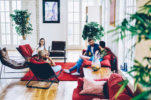Preview: Diverse woman and man 20s have homey conversation on leisure in stylish hostel living room