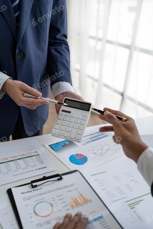Preview: Financial analyst analyzing business financial report on laptop and graph document during profit cal
