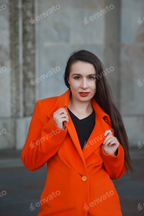 Preview: Fashionable young beautiful stylish woman in red coat walking on street