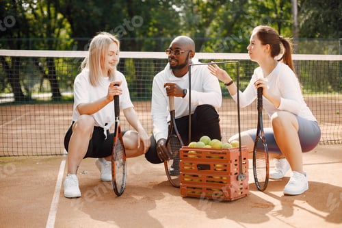 Preview: Two women and black race trainer at tennis court