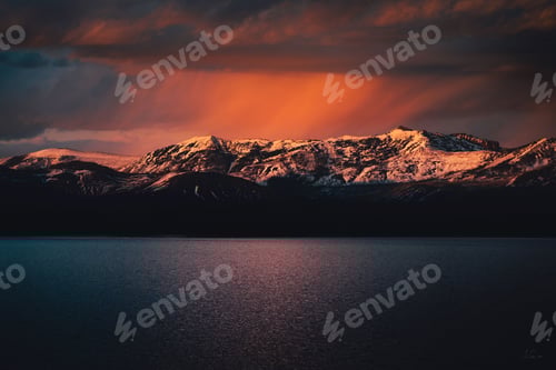 Preview: Sunset over snow-capped mountains reflecting in a calm lake at Yellowstone National Park.