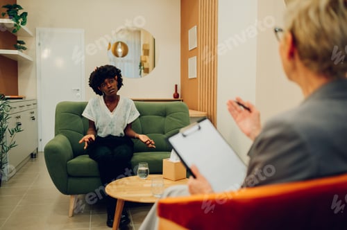 Preview: An african american woman is sitting with her psychotherapist.