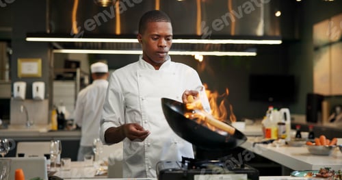 Preview: Black man, chef and fire with frying pan in kitchen at restaurant for fine dining, meal and creativ
