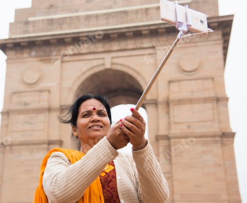 Preview: Tourist taking selfie with smart phone in front of India Gate, Delhi, India.